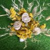 A vibrant dried yellow flowers bouquet featuring statice, sola wood roses, and bunny tails in a rustic vase
